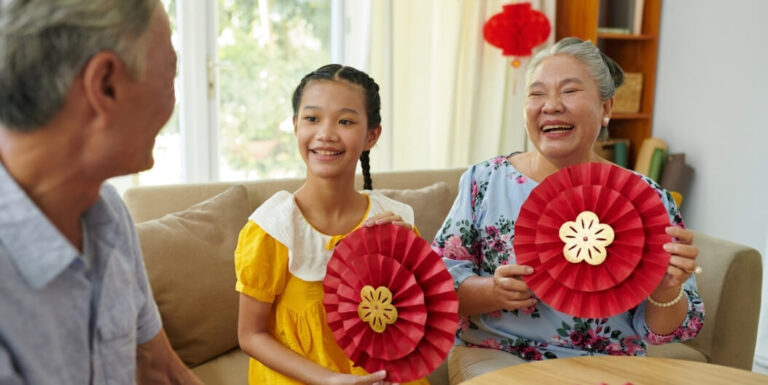 Elderly Woman and Granddaughter Holding Holiday Crafts in Memory Care