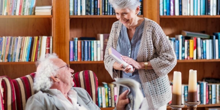 Elderly Couple Sharing Books in a Library at an Independent Living Facility