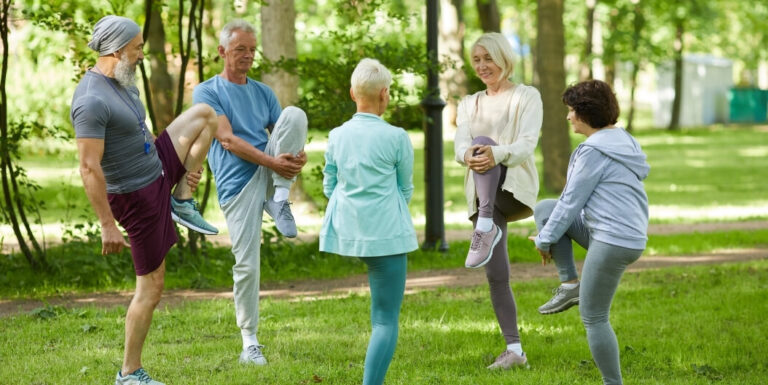 Active Elderly Residents Stretching Outdoors during a Summer Fitness Class at Independent Living Facility